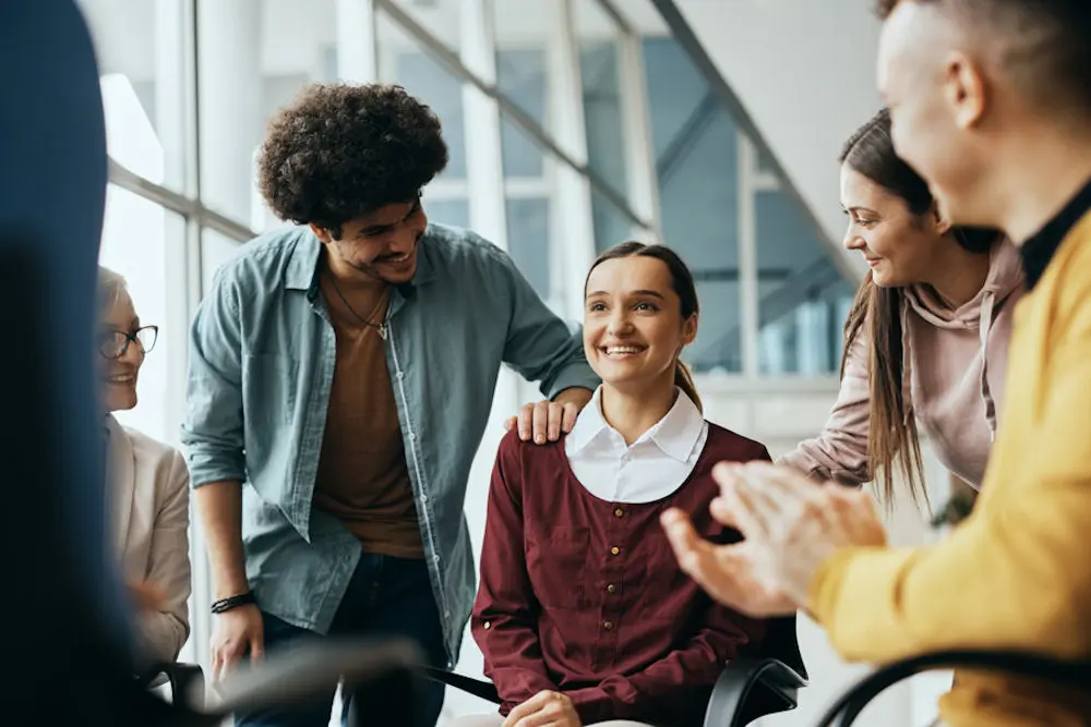 Young happy woman receives support from attenders of group therapy at mental health center. group attending dual diagnosis treatment session in West Virginia
